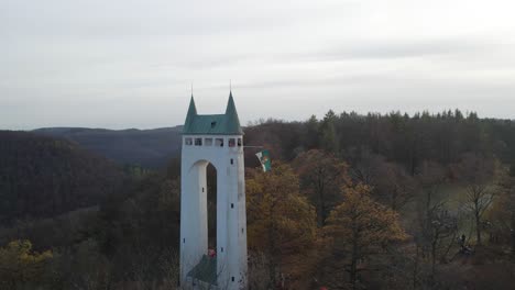 Aerial-view-of-an-old-tower-in-the-Swabian-Alb-with-a-flag-waving-in-Slow-Motion