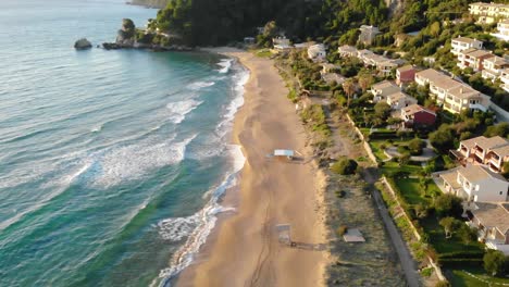 Aerial-view-of-empty-beach-with-waves-crashing-at-sunset,-Slow-Motion,-60-fps
