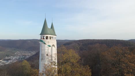 Aerial-close-view-of-an-old-tower-in-the-Swabian-Alb-with-a-flag-waving-in-Slow-Motion