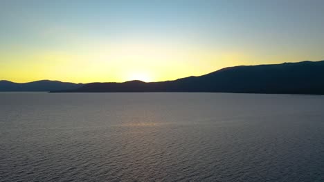 Gelbe-Sonne,-Die-Hinter-Dem-Schönen-Lake-Tahoe-In-Den-Seara-Nevada-Mountains-In-Kalifornien-Untergeht,-Alpenglühen-Auf-Unberührtem-Berggipfel---Luftdrohnenansicht