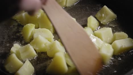 Close-up-View-of-Person-Stirring-in-Pan-With-Frying-Potatoes