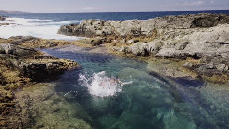 Piscina-Oceánica-De-Agua-Natural-De-La-Isla-Canaria-De-Fuerteventura,-Joven-Mujer-Multirracial-De-Raza-Mixta-Bucear-Y-Nadar-En-Un-Entorno-Natural-Escénico