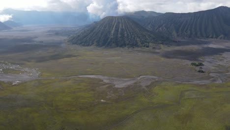 aerial-view,-in-the-morning-the-beautiful-Mount-Bromo-area-is-slightly-smoky-and-the-savanna-is-green