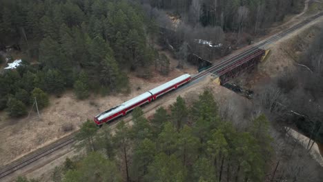 AERIAL:-Old-Red-Train-Rides-Across-Bridge-Over-River