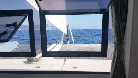Front-view-of-catamaran-zooming-out-through-window-inside-the-cabin