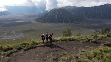 aerial-view,-in-the-morning-the-Mount-Bromo-area-and-three-people-waving-to-the-drone