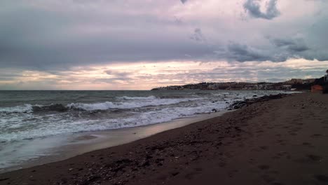 Walking-along-the-coastline-of-Mijas,-Spain,-on-a-dark-cloudy-day