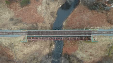 AERIAL:-River-Flows-Below-Old-Railroad-Bridge-in-Lithuania
