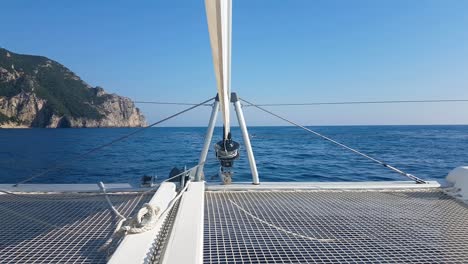 Vista-De-Mástil-Horizontal-Frontal-En-Catamarán-En-Mar-Tranquilo,-Día-Soleado,-Cielo-Azul