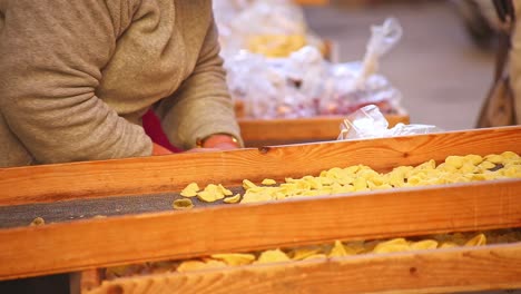 Close-up-of-ladies-hands-preparing-and-selling-food-at-Italian-market
