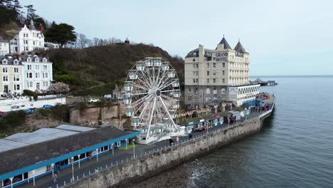 Llandudno-pier-Victorian-promenade-Ferris-wheel-attraction-and-Grand-hotel-resort-aerial-wide-orbit-left-view