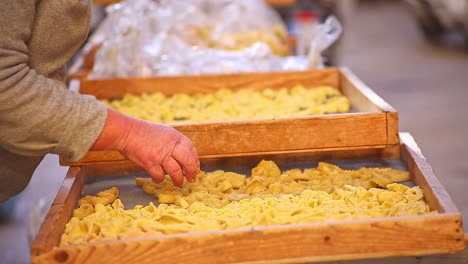 Close-up-elderly-lady-selling-pasta-in-authentic-local-Italian-market
