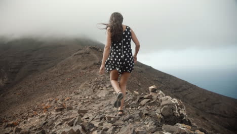 Mujer-Joven-Caminando-Sobre-La-Cresta-De-Una-Montaña-En-Fuerteventura-Islas-Canarias-España