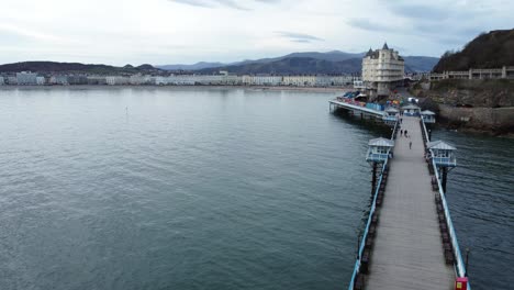 Scenic-aerial-view-Llandudno-seafront-town-following-Victorian-pier-above-boardwalk