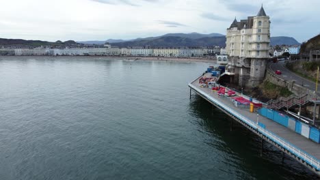 Scenic-aerial-view-along-Victorian-Llandudno-pier-boardwalk-seafront-heading-towards-town-hotel-attraction