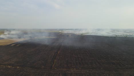 Aerial-footage-towards-charred-farmlands-already-tilled-and-this-is-air-pollution,-Grassland-Burning,-Pak-Pli,-Nakhon-Nayok,-Thailand