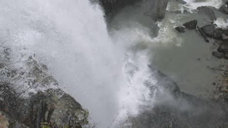Video-In-Zeitlupe,-Das-Dem-Wasser-Eines-Wasserfalls-Folgt,-Während-Es-Auf-Die-Felsen-Darunter-Fällt