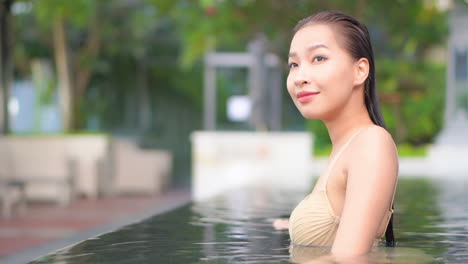 A-close-up-of-a-woman-in-a-swimming-pool-turns-her-head-to-look-at-the-camera