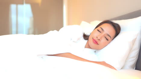 Schöne-Asiatische-Frau,-Die-In-Einem-Bequemen-Bett-Mit-Weißer-Bettwäsche,-Kissen-Und-Bettdecke-Schläft