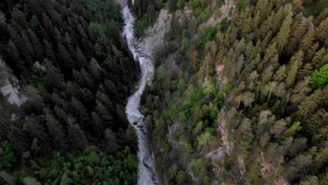 Top-down-aerial-view-of-Rhone-river-valley-in-Valais,-Switzerland-with-a-pan-up-toward-the-town-of-Fiesch