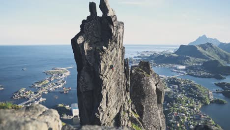 Person-trad-climbing-on-extremely-dangerous-rocky-cliff-in-Norway,-Svolværgeita-Lofoten