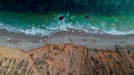 Aerial-view-of-the-rocky-shoreline-of-Nerja,-moving-sideways-slowly