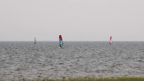Wind-Surfers-Sailing-on-an-Overcast-Windy-Day-in-the-Distance-in-Pattaya,-Thailand