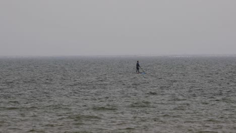 Wind-Surfer-Trying-to-Pull-his-Sail-up-in-the-Water-on-an-Overcast-Day-in-Pattaya,-Thailand