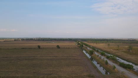 Aerial-footage-sliding-to-the-left-revealing-Pak-Pli-and-farmlands-also-grassland-protected-for-migratory-bird-species-from-all-over-the-world,-Nakhon-Nayok,-Thailand