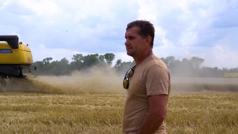 Ein-Weizenbauer-Betrachtet-Einen-Mähdrescher,-Der-Im-Sommer-In-Der-Ukraine-Weizenfelder-Erntet