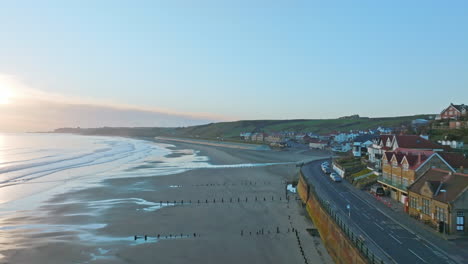 Sandsend,-Whitby,-North-Yorkshire-Coast-aerial-drone-movement-along-the-sea-front-backwards