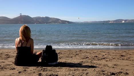 Woman-Relaxing-at-the-Shore-as-she-stares-at-the-Golden-Gate-Bridge