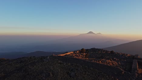 Blick-Auf-Eine-Archäologische-Stätte-über-Dem-Wunderschönen-Berg-Tlaloc-In-Mexiko-Mit-Blick-Auf-Die-Gesamte-Bergkette-Im-Hintergrund-Bei-Sonnenuntergang