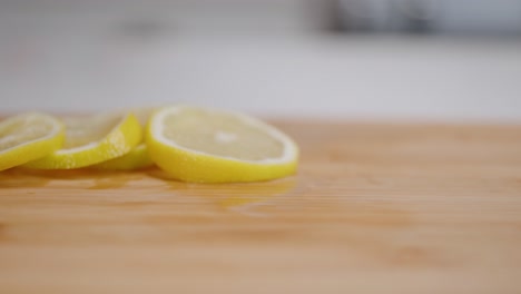 Eine-Frische-Gelbe-Zitronenscheibe-Dreht-Sich-Und-Fällt-In-Zeitlupe-Auf-Einen-Zitronenstapel
