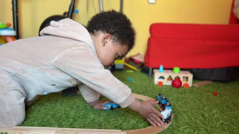 Zwei-Jahre-Altes-Afroeuropäisches-Kind,-Das-Zu-Hause-Mit-Seiner-Spielzeugeisenbahn-Spielt