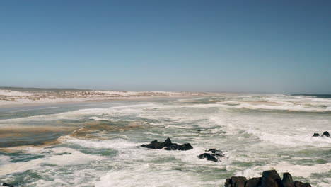 Turbulente-Wellen,-Die-Nacheinander-Auf-Felsen-Und-Den-Strand-Des-Westküsten-nationalparks-In-Südafrika-Schlagen---Feste-Drohnenaufnahme