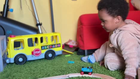 Zwei-Jahre-Altes-Afroeuropäisches-Kind,-Das-Zu-Hause-Mit-Einer-Spielzeugeisenbahn-Spielt