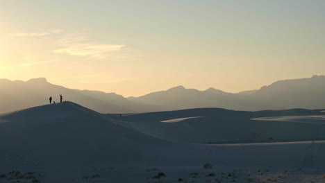Weite-Aussicht-Auf-Den-Sonnenuntergang-Von-Menschen,-Die-Auf-Sanddünen-Im-White-Sands-National-Park-Stehen