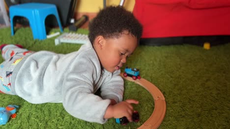 Zwei-Jahre-Altes-Exotisches-Und-Süßes-Afroeuropäisches-Kind,-Das-Zu-Hause-Mit-Seiner-Spielzeugeisenbahn-Spielt