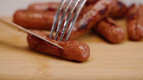 Sharp-knife-slices-through-cooked-breakfast-sausage-in-slow-motion