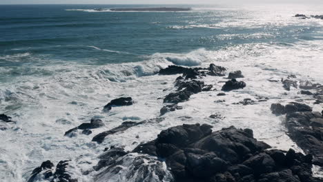 Aerial-View-Of-Foamy-Ocean-Waves-Crashing-On-The-Rocks-At-The-Beach-In-West-Coast-National-Park,-South-Africa---drone-shot