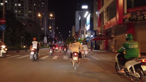 Stabilized-motorcycle-traveling-shot-at-night-in-Ho-Chi-Minh-City-or-Saigon,-Vietnam