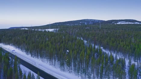 Aerial-–-Winter-Landscape-Of-Northern-European-Areas-With-Highway-Among-Forest