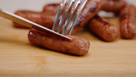 Sharp-knife-slices-through-breakfast-sausage-in-slow-motion