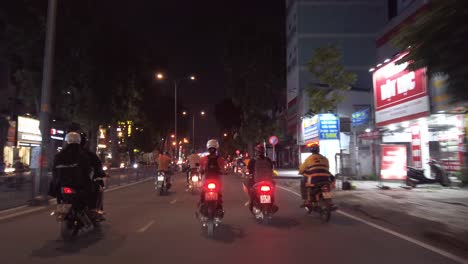 Stabilized-motorcycle-traveling-shot-at-night-in-Ho-Chi-Minh-City-or-Saigon,-Vietnam