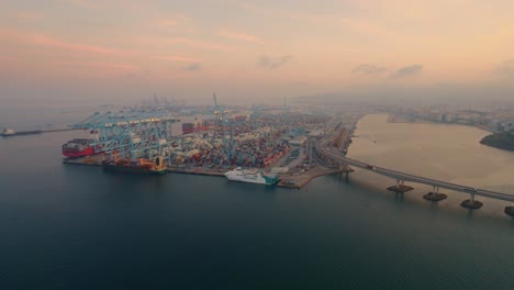 Aerial-view-towards-Port-of-Algeciras-stacked-containers-and-loading-cranes-terminal-at-sunrise