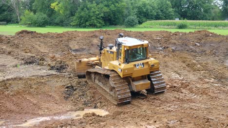 Caterpillar-Bulldozer-maneuvers-through-mud-to-prepare-a-site-for-a-new-pond-at-a-land-development-site