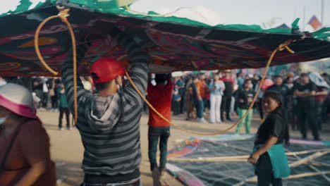 Gruppe-Von-Männern,-Die-Während-Des-Sumpango-Kite-Festivals-In-Sumpango,-Sacatepequez,-Guatemala,-Einen-Riesigen-Drachen-Tragen