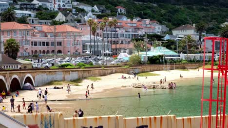 Tourists-swim-in-Kalk-Bay-sunny-ocean-Cape-Town-coastline-beach-South-Africa