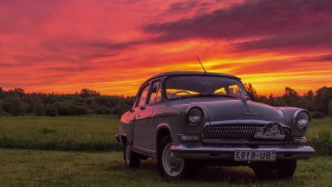 Vibrant-orange-sunset-in-the-summer-sky-with-a-vintage-car-in-the-foreground---time-lapse